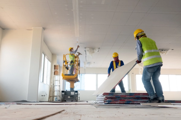 Image of construction works inside building a home with drywall.